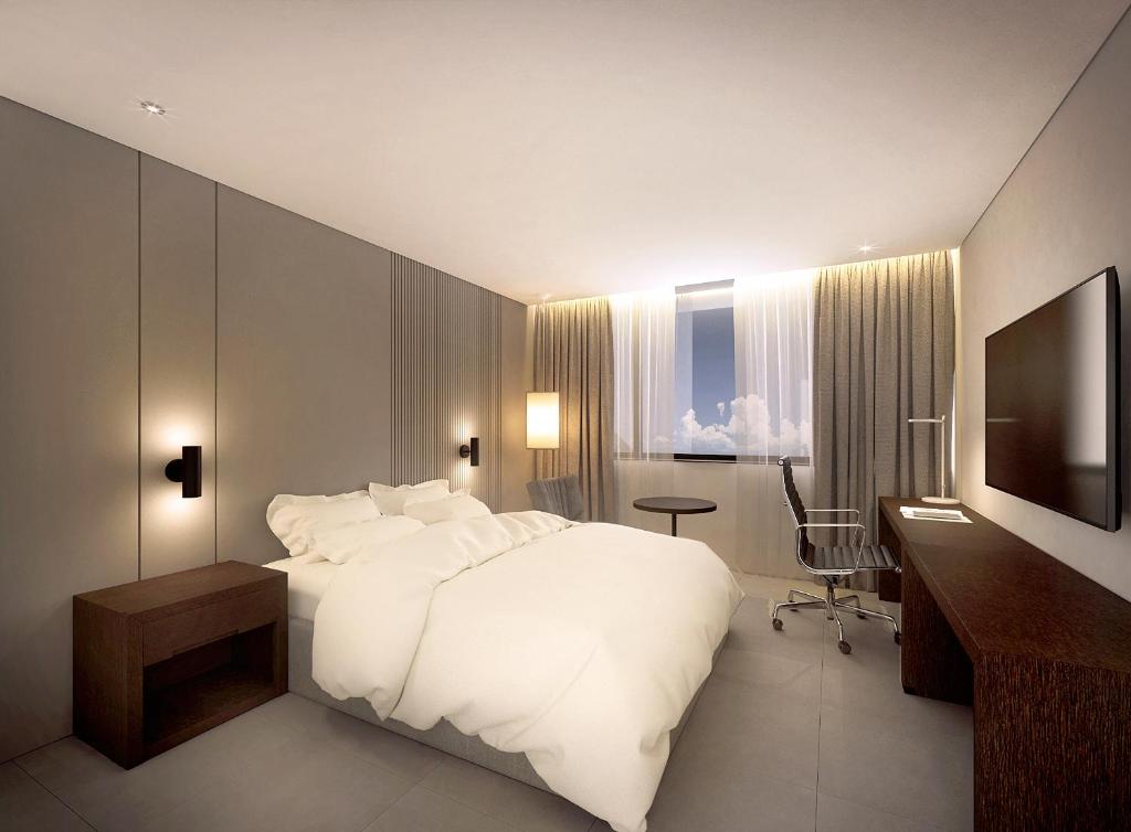 Dormitorio con cama, escritorio y TV en Crown Hotel Changwon en Changwon