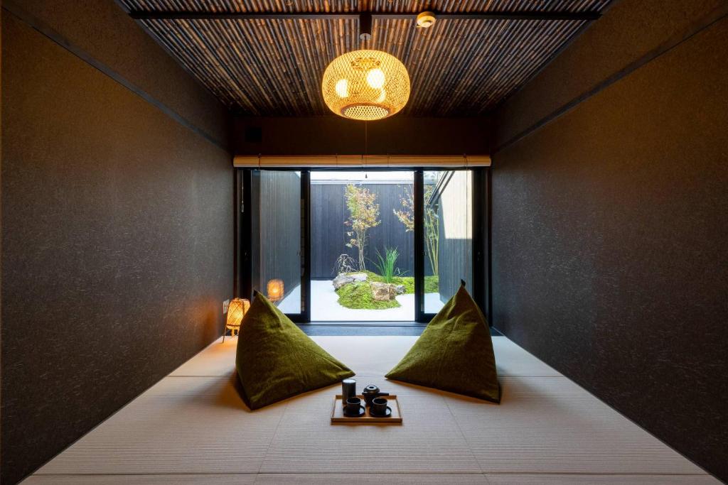 um quarto com uma cama com almofadas verdes e uma janela em Yoinotake Machiya House em Quioto
