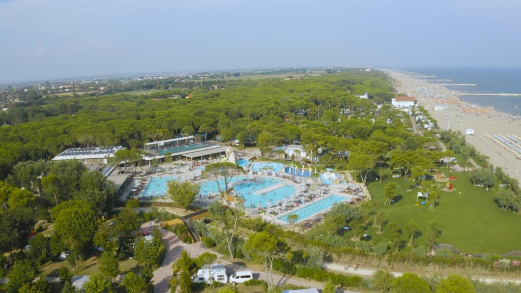 - une vue aérienne sur un complexe avec une piscine et une plage dans l'établissement Victoria Mobilehome in Camping Village Mediterraneo, à Cavallino-Treporti