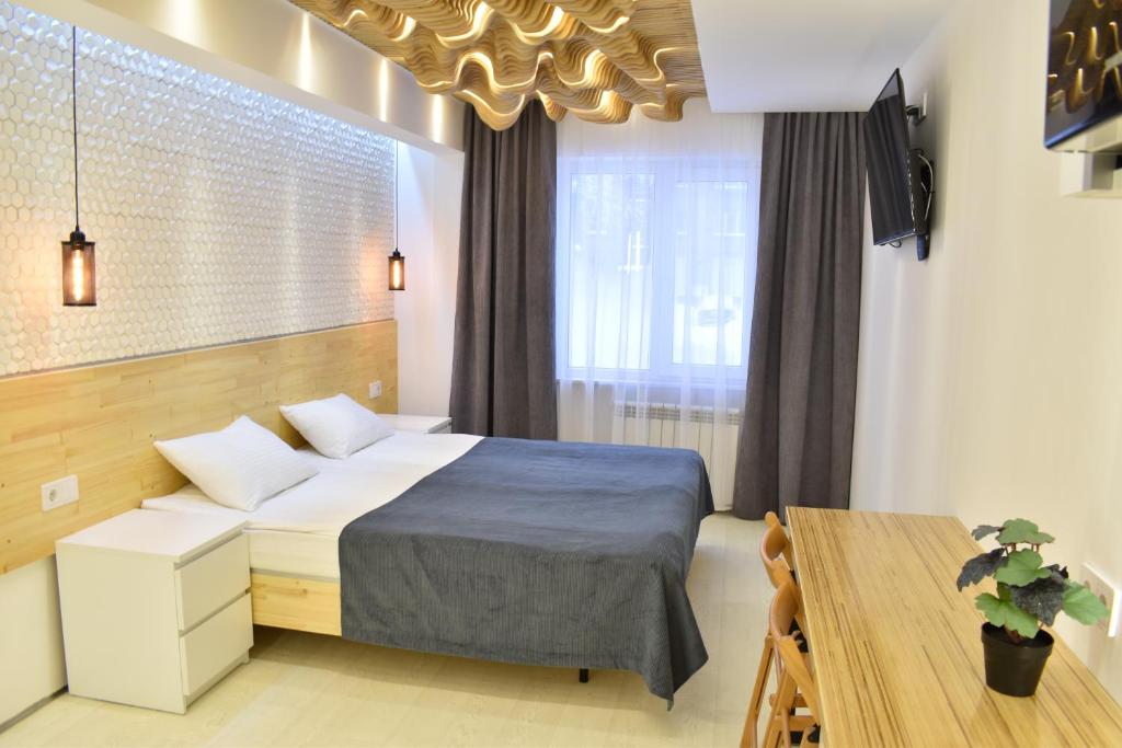 チェレポヴェツにあるApartments LOFTのベッドルーム1室(ベッド1台、テーブル、窓付)