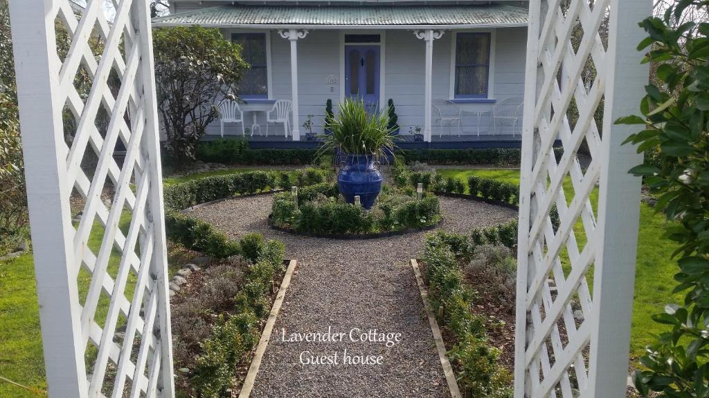 a view of a garden through a white fence at Lavender Cottage in Greytown