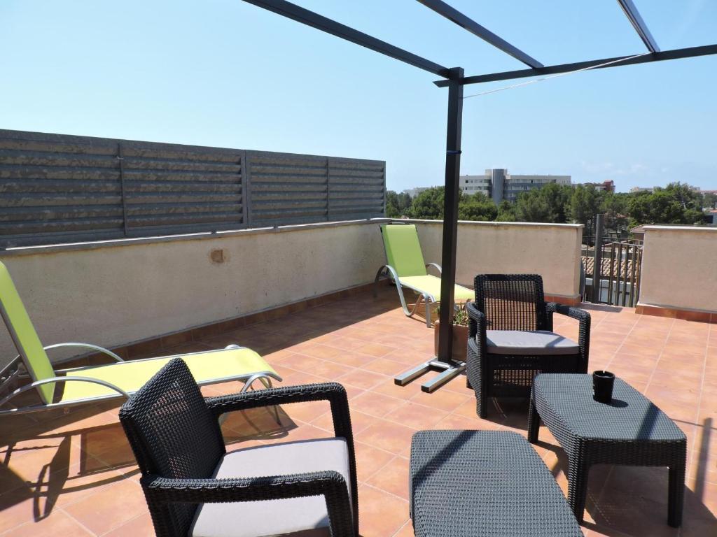 eine Terrasse mit Stühlen und Tischen auf dem Dach in der Unterkunft Doree 583 in Miami Platja