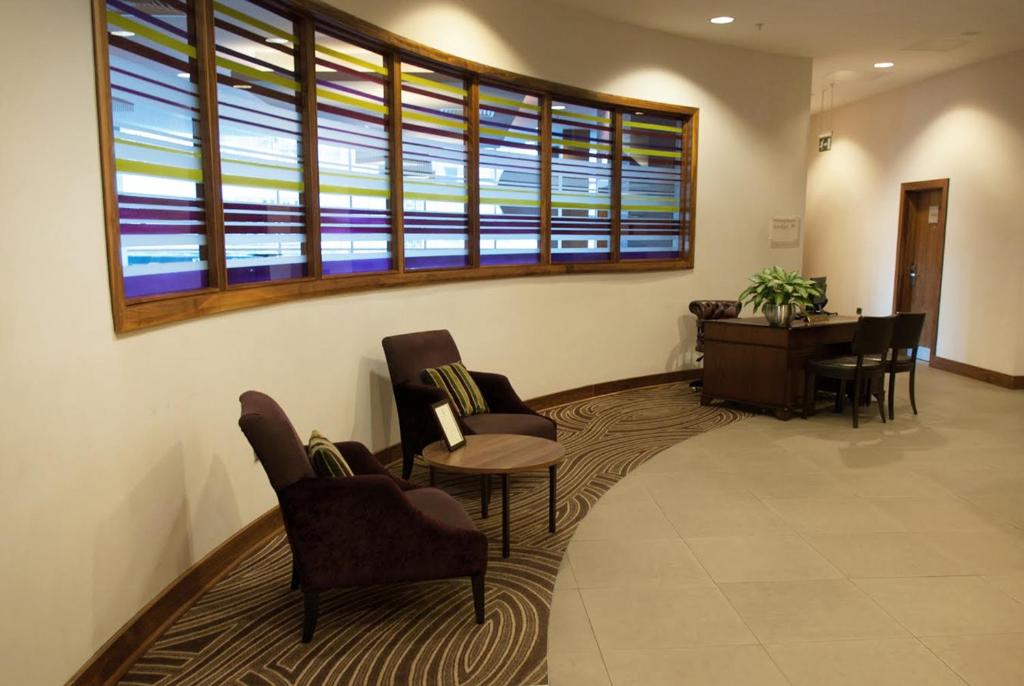 a waiting room with chairs and a table and a window at Leonardo Hotel Aberdeen in Aberdeen