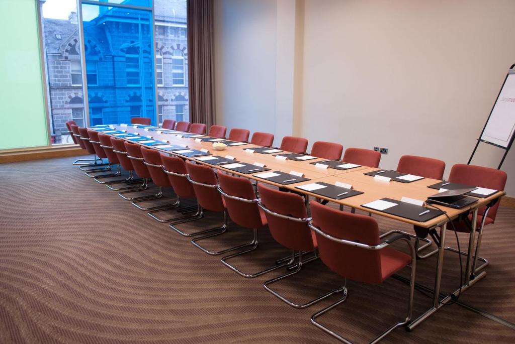 a conference room with a long table and chairs at Leonardo Hotel Aberdeen in Aberdeen