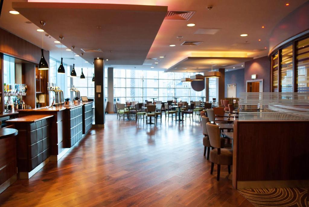 a restaurant with a bar and some tables and chairs at Leonardo Hotel Aberdeen in Aberdeen