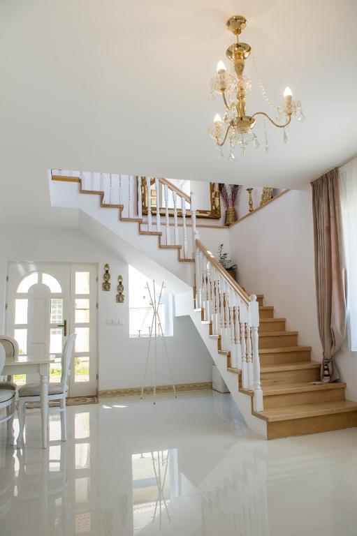 a staircase in a home with a chandelier at Vila Maria in Râşnov