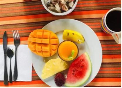 南威的住宿－HOMELAND SWAHILI LODGE Nungwi Backpacker Apartments BUDGET，桌上一盘早餐食品和水果