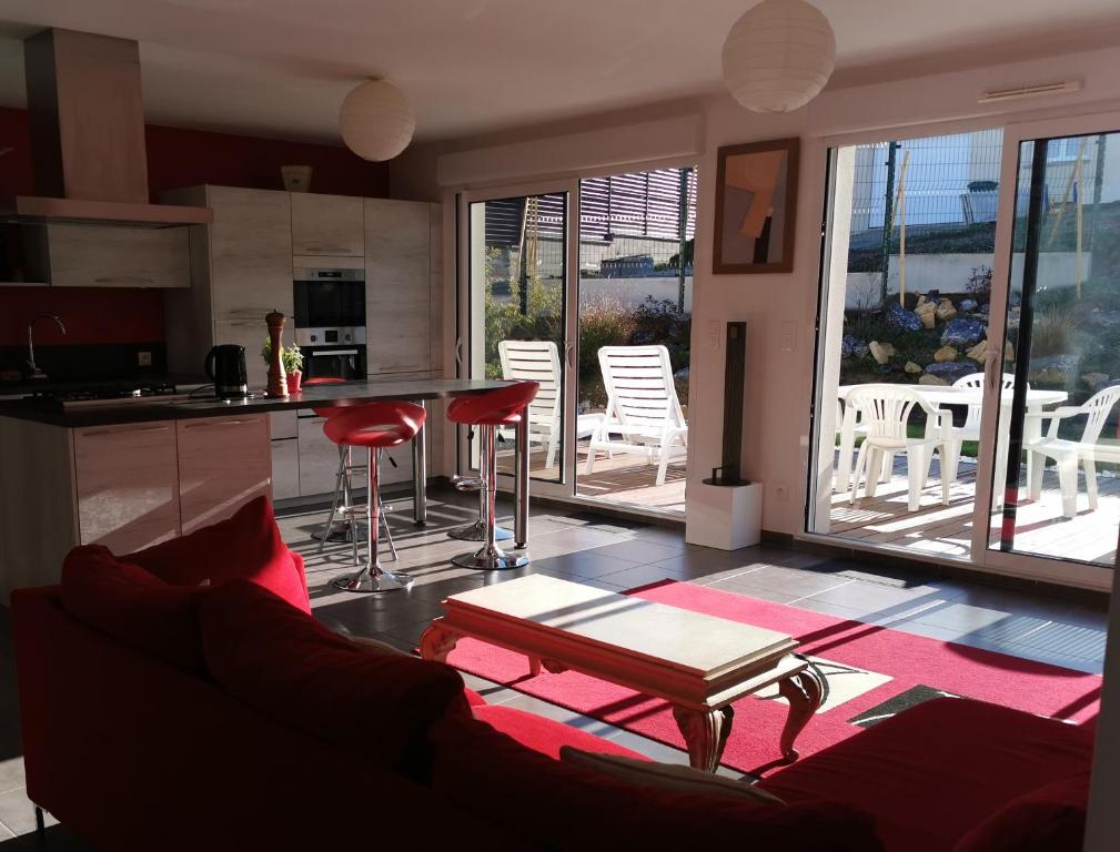 un soggiorno con divano e una cucina con sedie di Chez Frédéric a Tomblaine