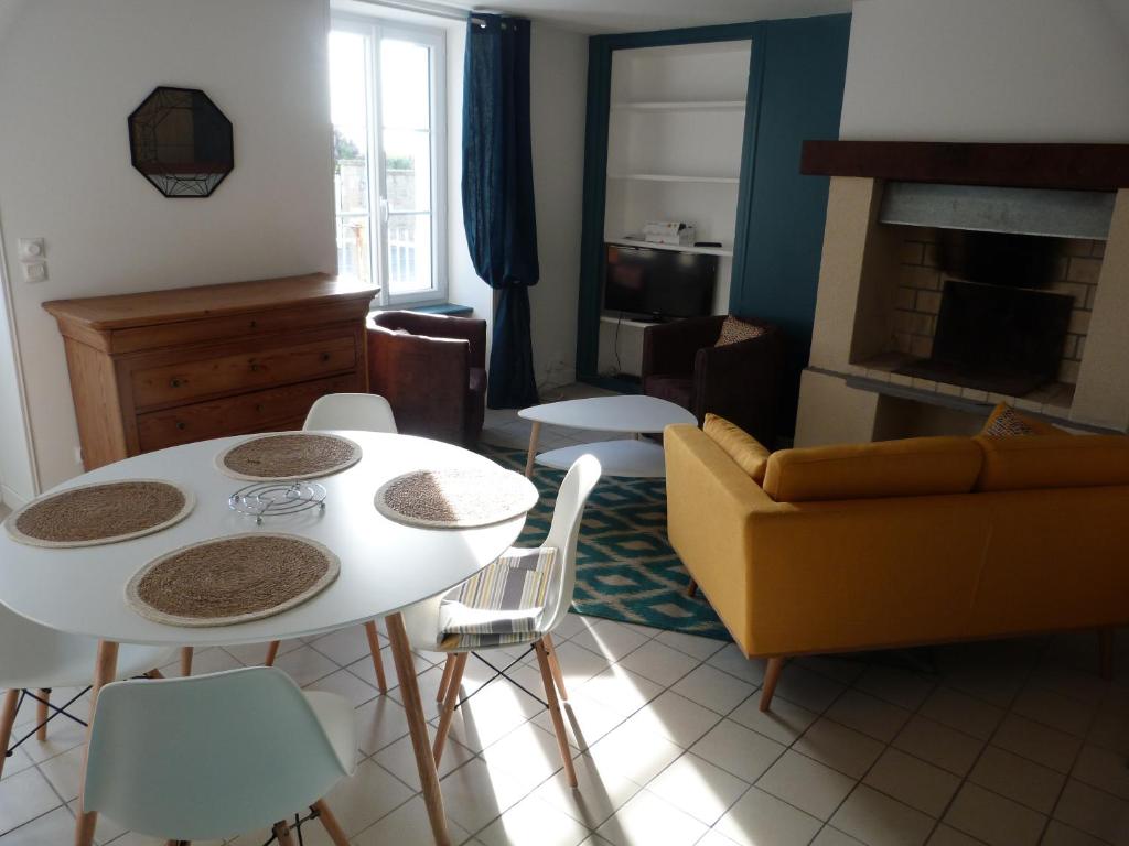 ポールバイユにあるGîte la presqu'ileのリビングルーム(ソファ、テーブル、椅子付)