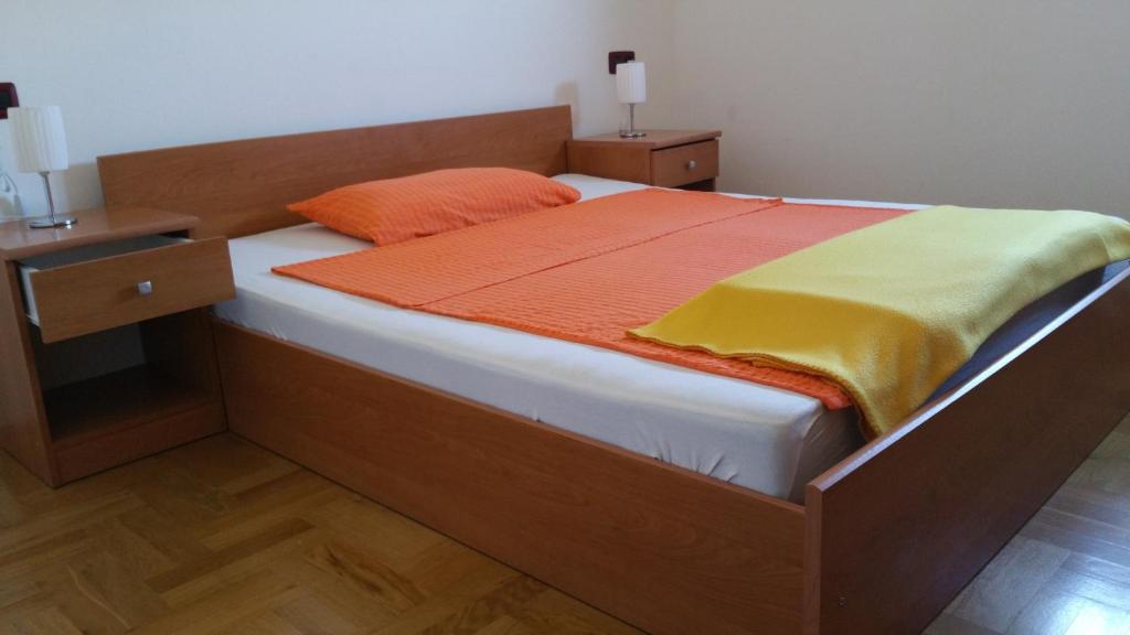 - un lit avec une couverture orange et jaune dans l'établissement Apartman Dana, à Premantura