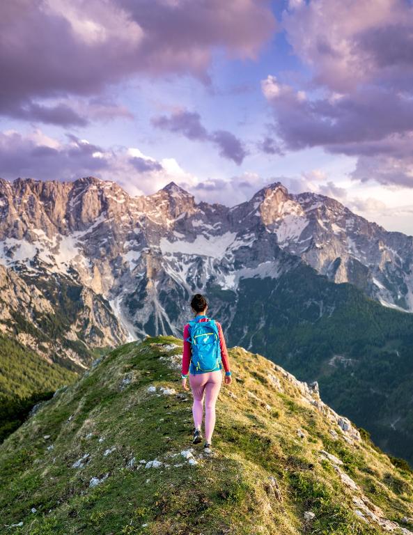 a person walking on top of a mountain at Tourist Farm Šenkova Domačija in Zgornje Jezersko