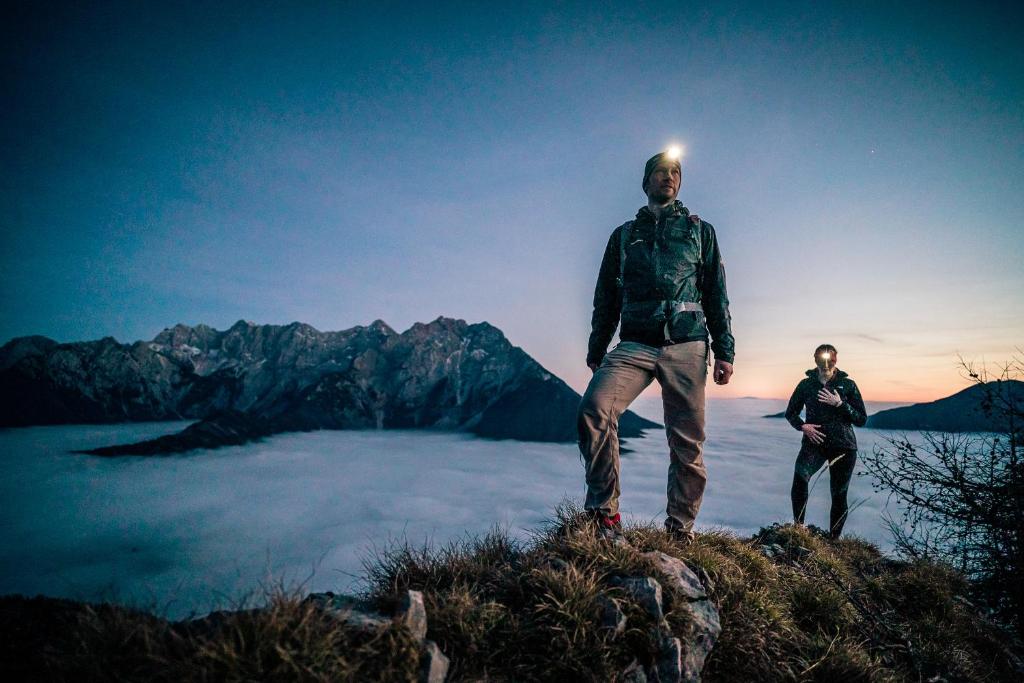 two men standing on top of a mountain at Tourist Farm Šenkova Domačija in Zgornje Jezersko