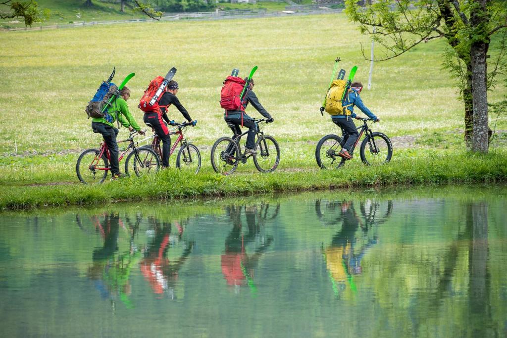 a group of people riding bikes next to a body of water at Tourist Farm Šenkova Domačija in Zgornje Jezersko