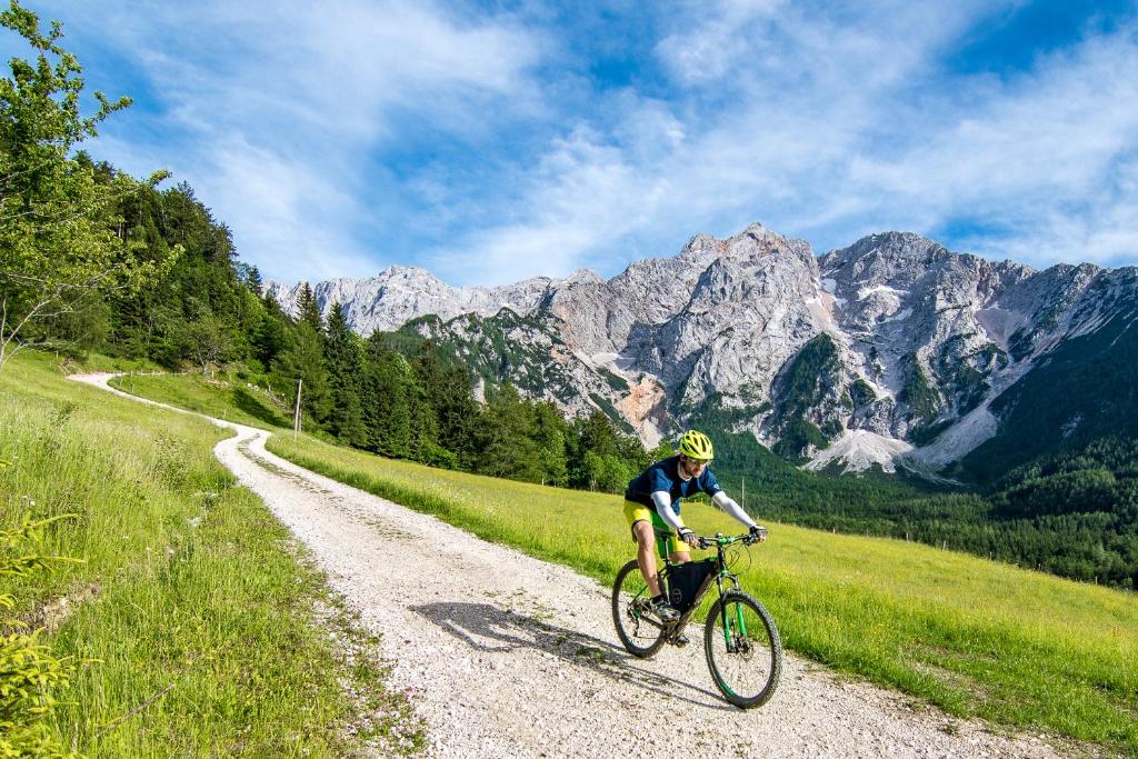 a person riding a bike down a dirt road at Tourist Farm Šenkova Domačija in Zgornje Jezersko