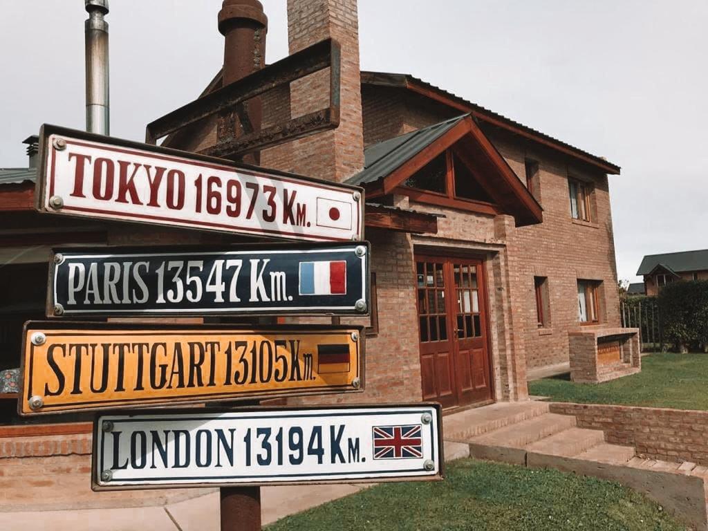 a group of street signs in front of a house at Hosteria Miyazato Inn in El Calafate