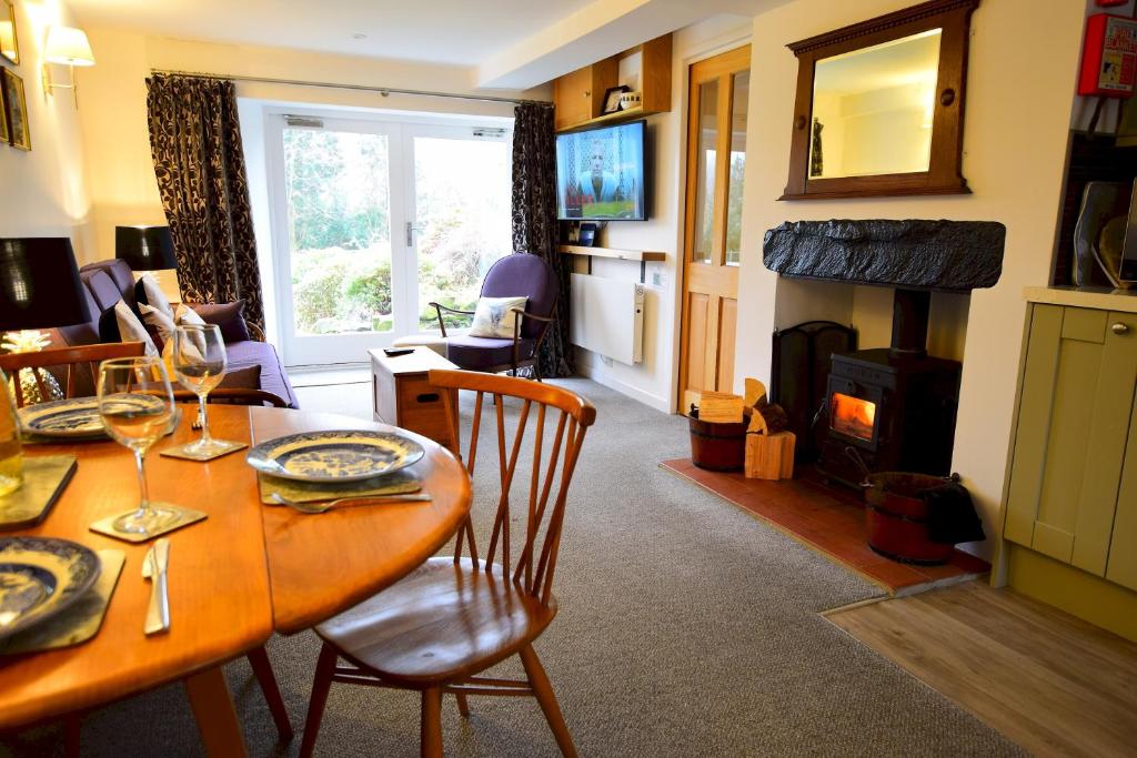 a living room with a table and a fireplace at Bottom Shop, Elterwater in Chapel Stile