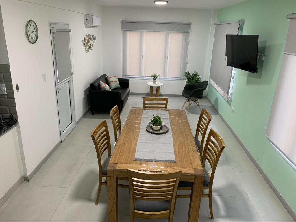 Una sala de estar con una mesa y sillas de madera. en Complejo Los Cardenales, en Monte Hermoso