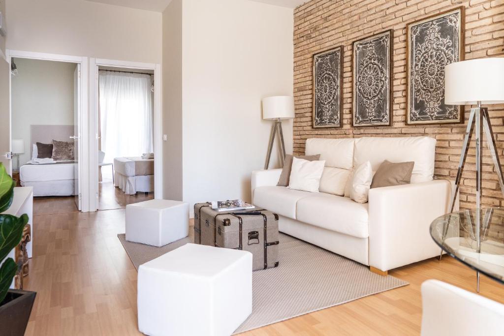 sala de estar con sofá blanco y pared de ladrillo en Puerto Rico Apartments Ruzafa en Valencia