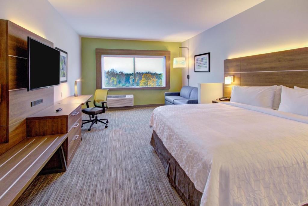 Spacious room and sitting area at Holiday Inn Express Charlotte Southwest with sofa, desk, and large window