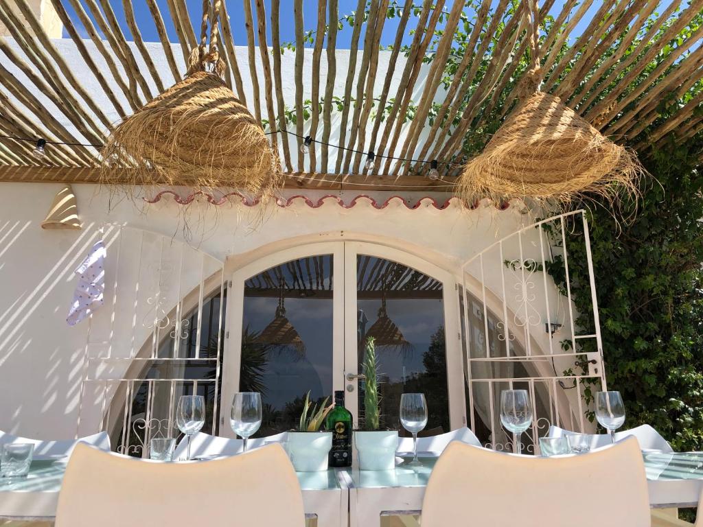 サンアントニオにあるMicasa Ibizaの窓際のテーブル(椅子付)とワイングラス