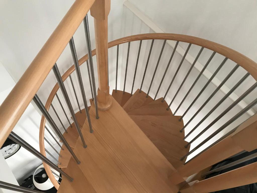 a wooden spiral staircase with a wooden rail at Southover Beach in Woolacombe