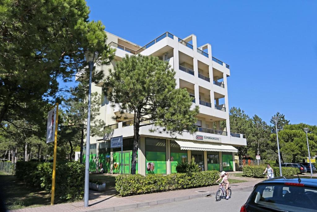 a person riding a bike in front of a building at Torcello in Bibione
