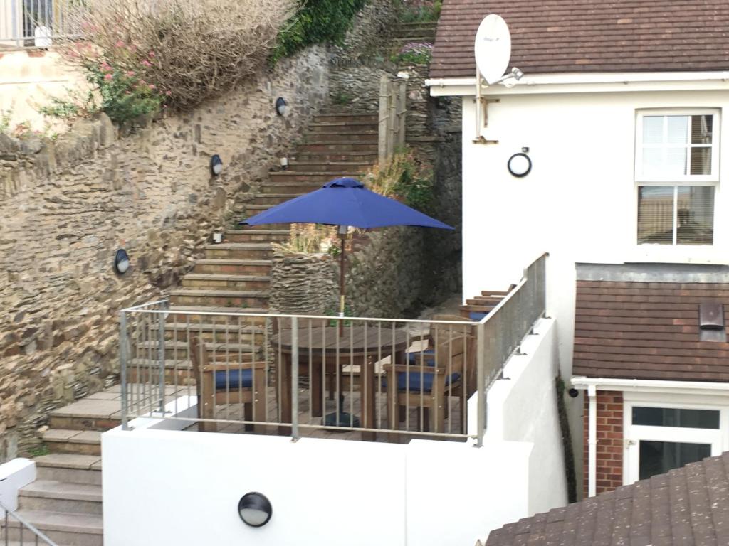 a blue umbrella sitting on a balcony with stairs at Southover Beach in Woolacombe