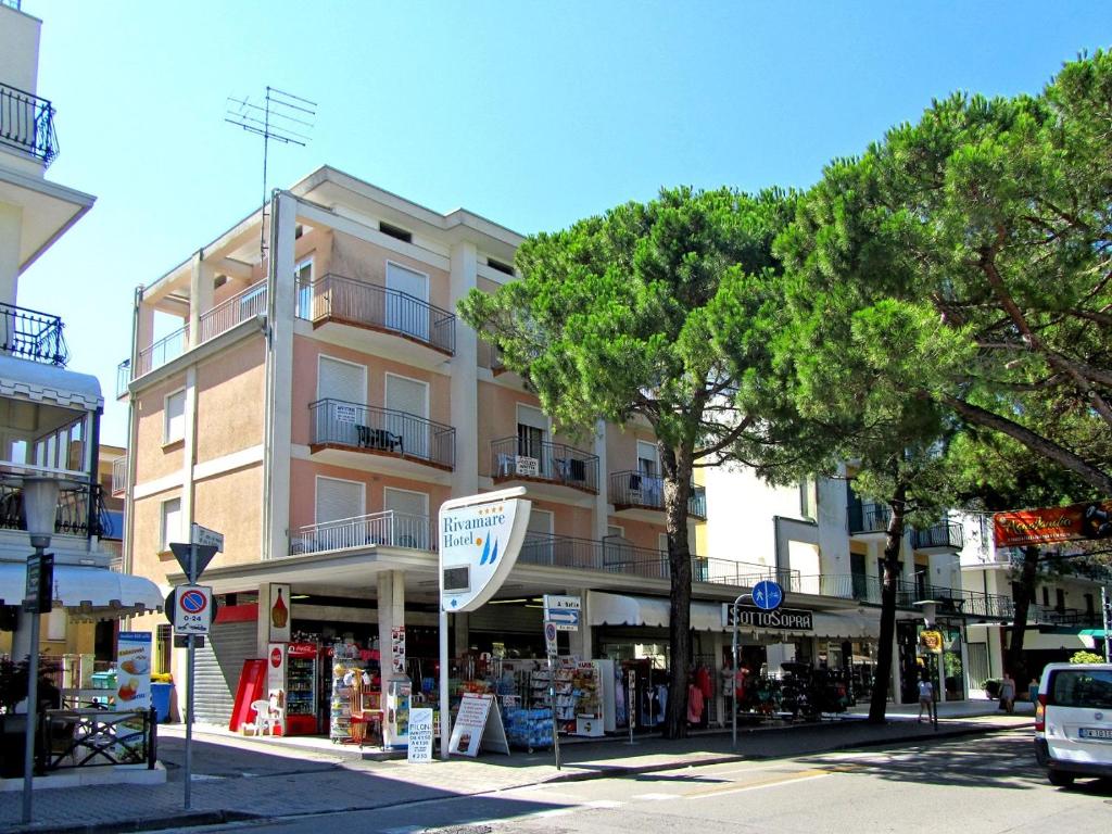 un edificio en una calle de la ciudad con árboles delante en Giannina, en Lido di Jesolo