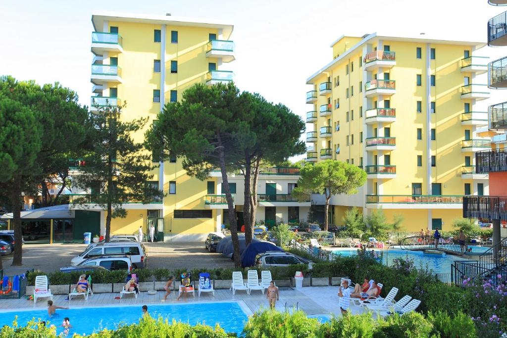 a group of people in a swimming pool with a building at Costa Del Sol in Lido di Jesolo