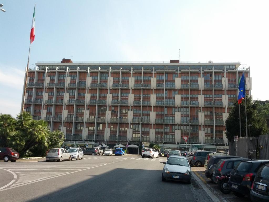 ein großes Gebäude mit Autos auf einem Parkplatz in der Unterkunft Residence Garden in Rom