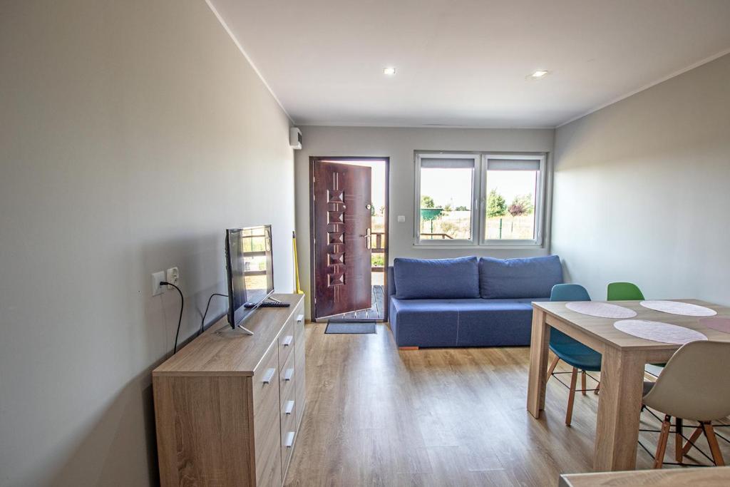 a living room with a blue couch and a table at Apartamenty Ster Darłówko in Darlowko