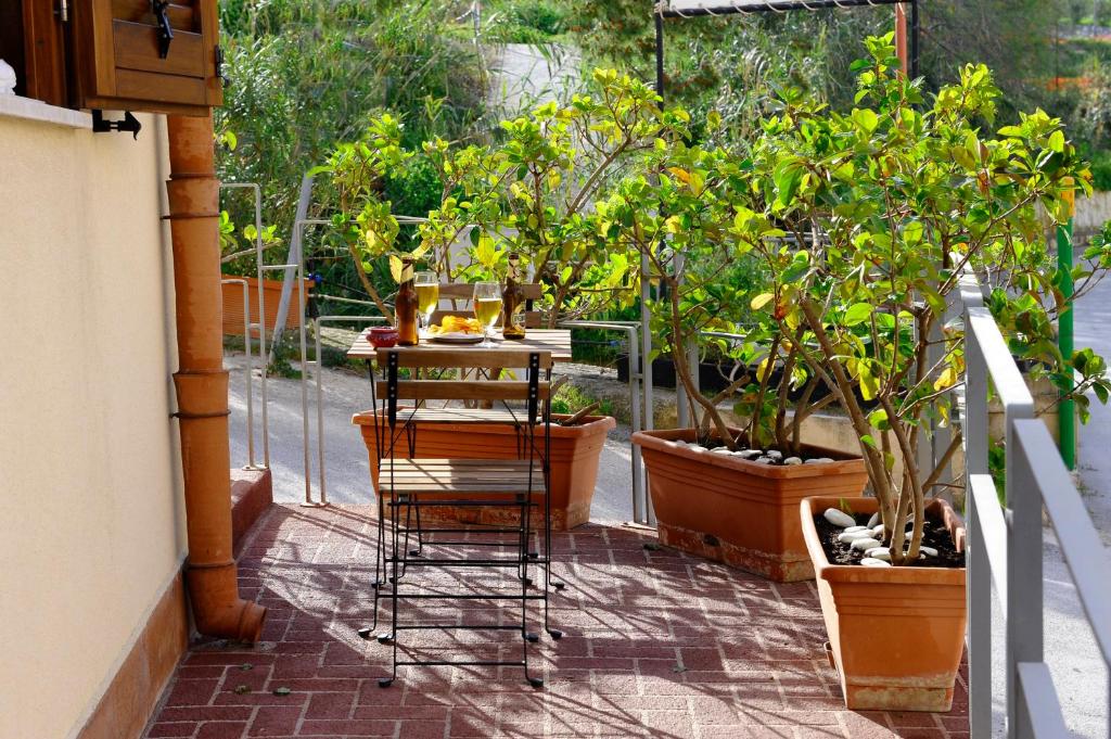 カステッランマーレ・デル・ゴルフォにあるCasa Vacanze Gorgoniaの鉢植えの植物が植えられたパティオ、テーブル付きのバルコニー