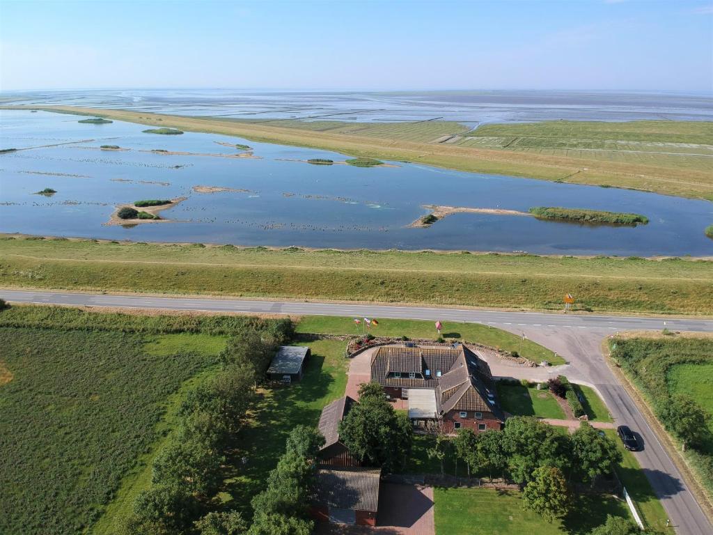 eine Luftansicht eines Hauses neben einem Wasserkörper in der Unterkunft Deichhus Nordseeliebe direkt am Deich - Nordsee - Dagebüll - Am Vogelreservat in Dagebüll