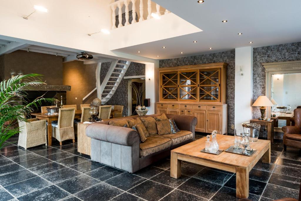 een woonkamer met een bank en een tafel bij Een prachtige en luxueuze vakantiewoning dat is Hof Leskensdaele in Geraardsbergen