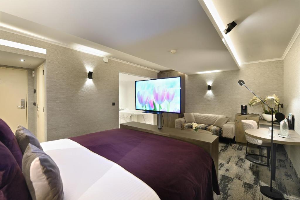 a hotel room with a bed and a flat screen tv at Hotel Charleroi Airport - Van Der Valk in Charleroi