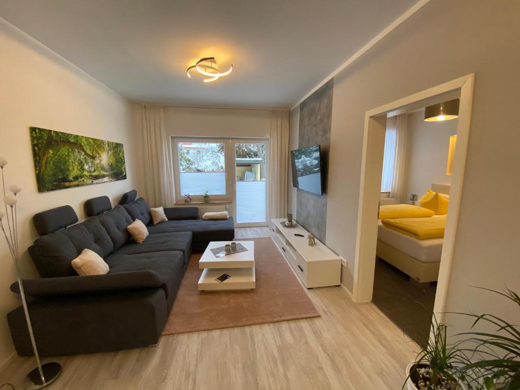 a living room with a couch and a bed at Pension Alscher Garni in Goslar