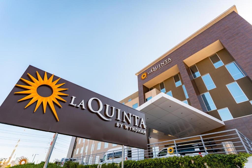 a building with a sign on the side of it at La Quinta by Wyndham Santiago Aeropuerto in Santiago