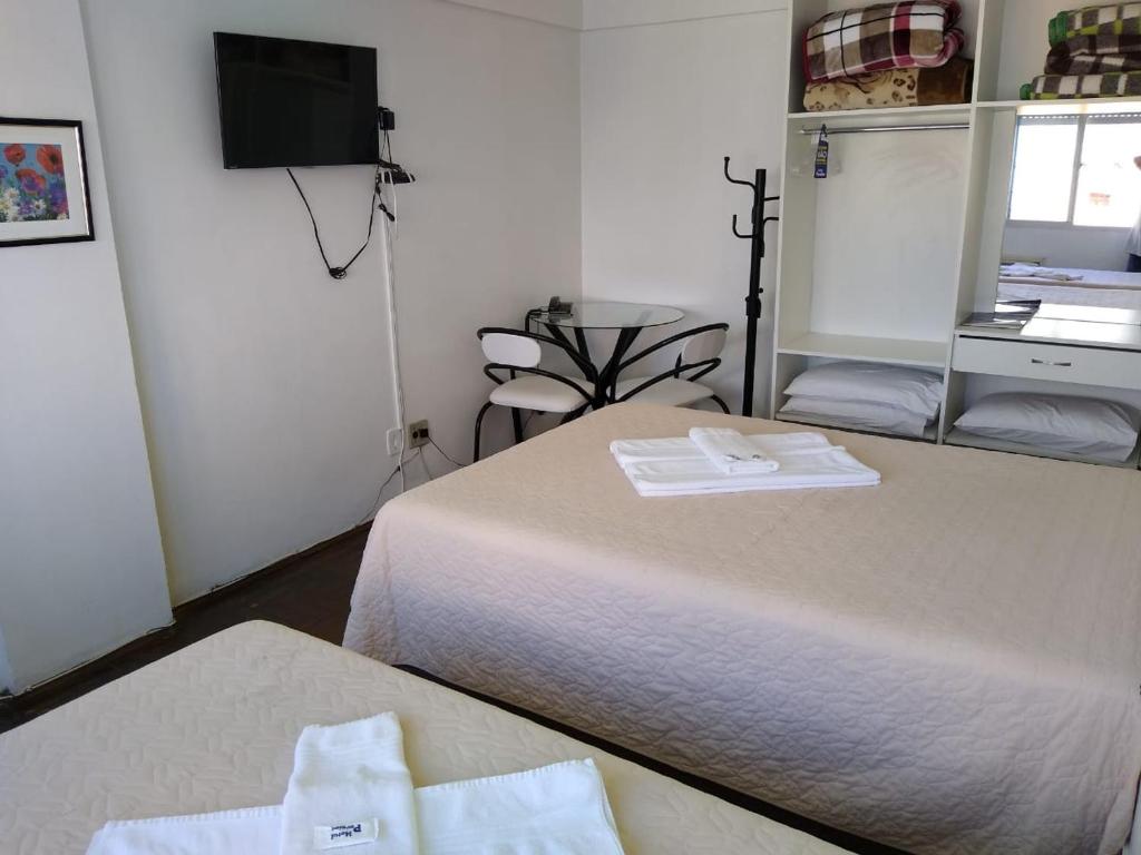 a hotel room with two beds and a tv at Hotel Paraiso in Santa Maria