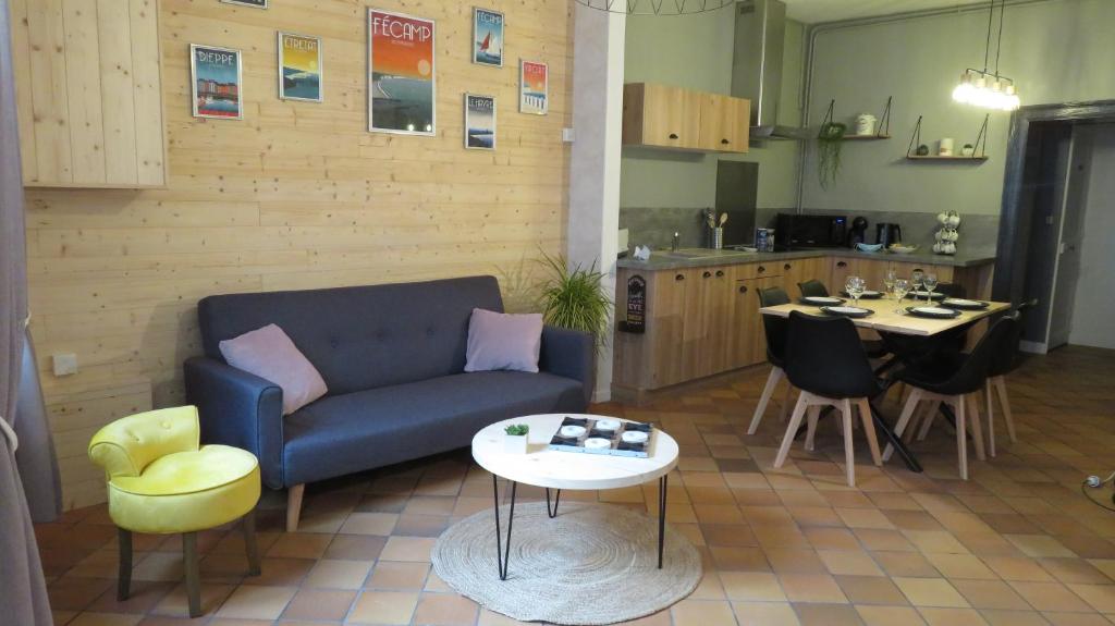 a living room with a couch and a table and a kitchen at L'étape Normande in Fécamp