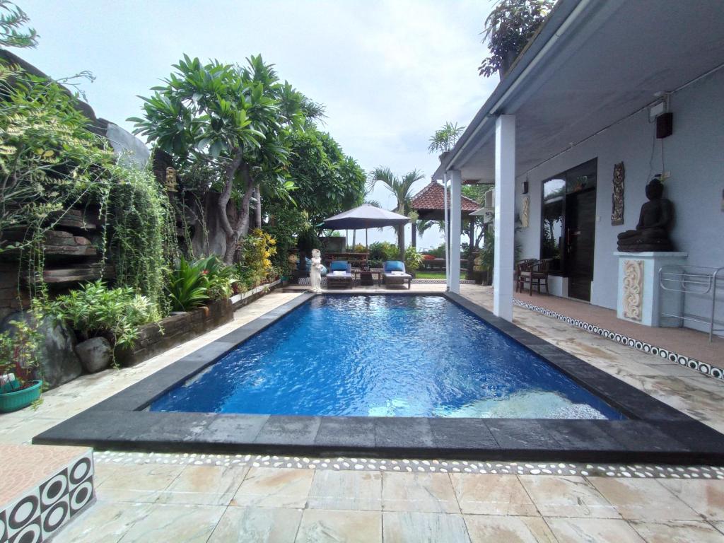 una piscina en el patio trasero de una casa en Khrisna Sunrise Homestay Tulamben en Tulamben