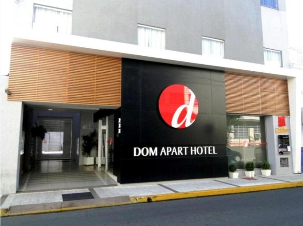 a building with a sign on the side of it at Summit Dom Apart Hotel in Lorena