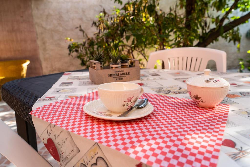 a table with two cups on a red and white table cloth at Casa Diana P3115 in Riola Sardo