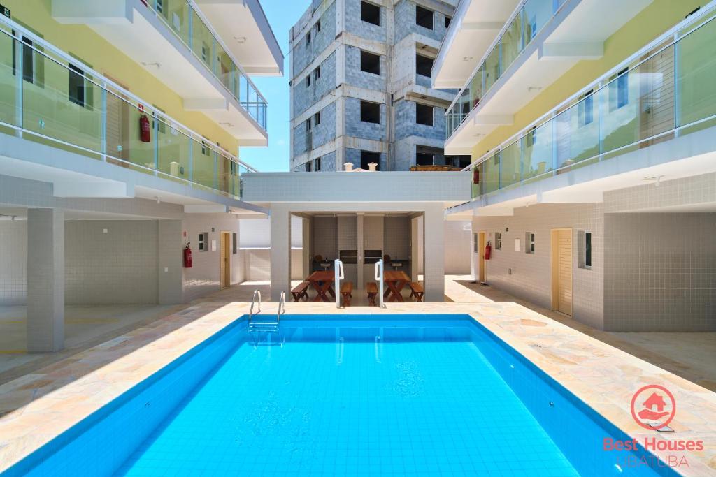 a swimming pool in a building with a building at Estúdios 3 Praias in Ubatuba