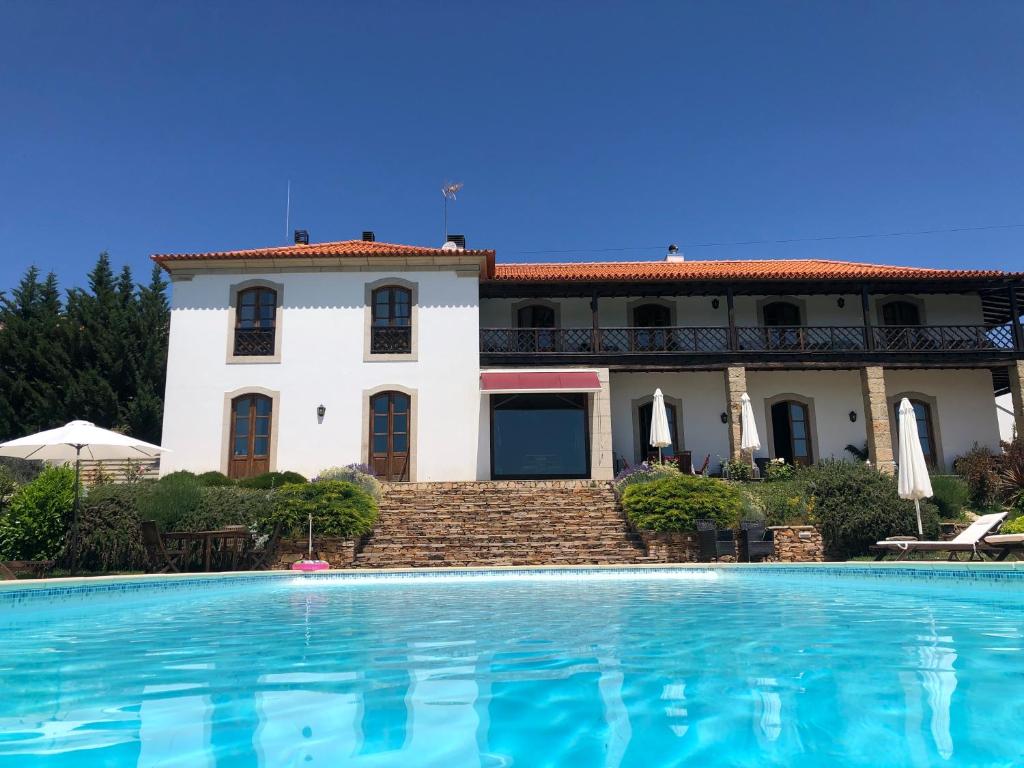 a house with a swimming pool in front of it at Quinta Da Pereira E Enricas Agro-Turismo in Vila Flor