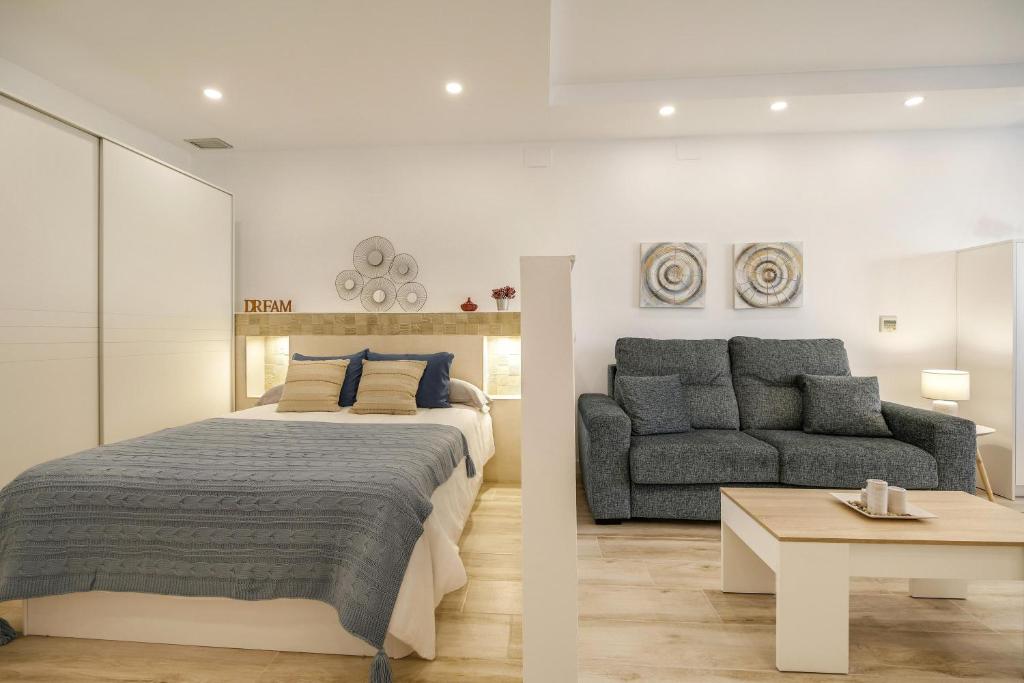 ein Schlafzimmer mit einem Kingsize-Bett und einem Sofa in der Unterkunft Apartamento Naypa with free parking in Cádiz