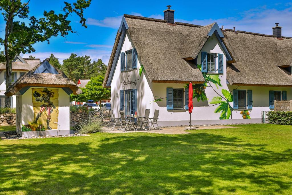 ein Haus mit einem Rasenplatz davor in der Unterkunft Pirateneiche in Glowe