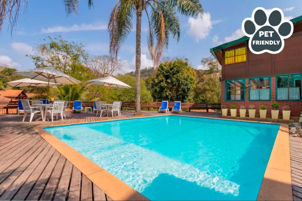 a pool at a resort with chairs and umbrellas at Wood House in Itaipava