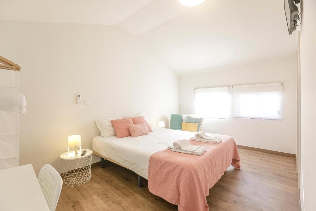 - une chambre avec un lit et une table avec une couverture rose dans l'établissement LovelyStay - 1st A Mirante, à Porto