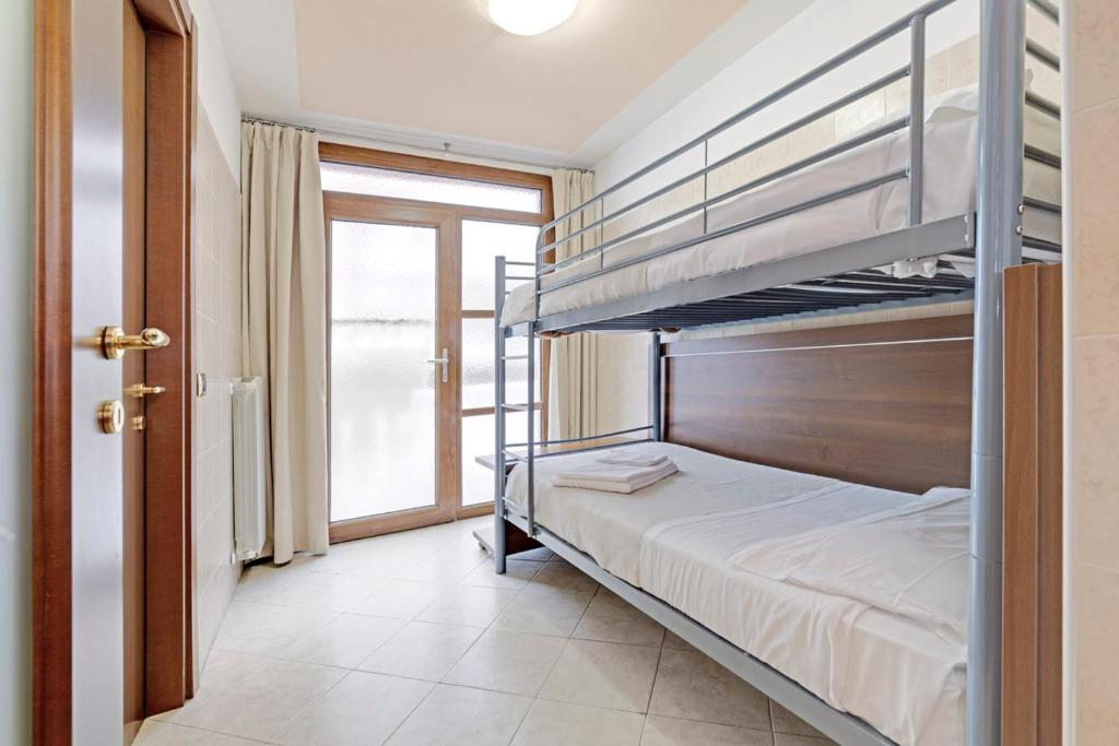 a bedroom with a bunk bed and a window at Hotel Grotto Bagat in Lavena Ponte Tresa