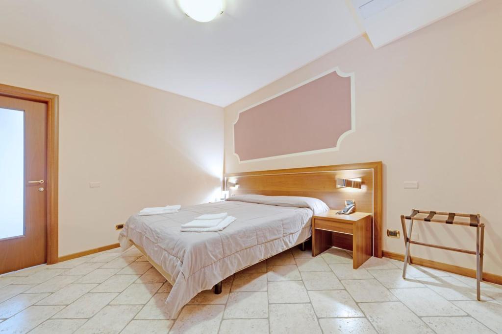 a bedroom with a large bed with a large screen at Hotel Grotto Bagat in Lavena Ponte Tresa